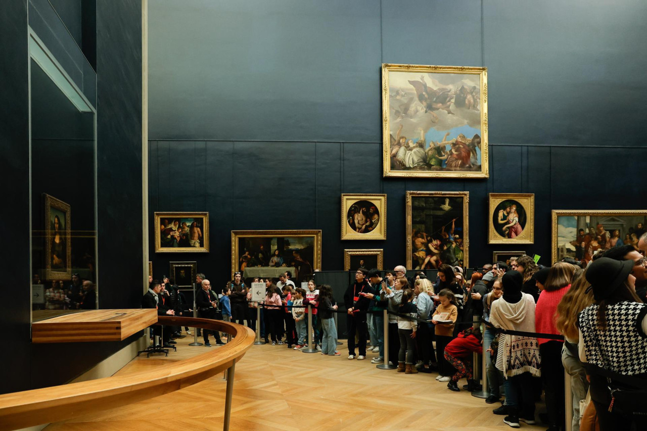 Visitantes toman fotografías de la Mona Lisa del pintor italiano Leonardo Da Vinci en el Museo del Louvre en París, Francia. EFE